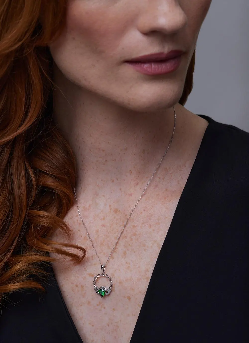 Close up of red haired model wearing Sterling Silver Green Stone Claddagh Pendant
